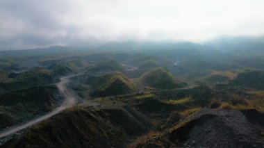 Volkanik bir bölgede, volkanik bir patlamadan arta kalan kum ve kaya yığınlarıyla çevrili 4K 'lık bir hava görüntüsü..