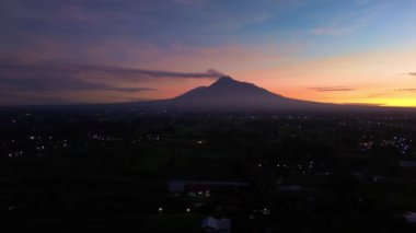 Gökyüzü hala karanlıkken ve güneş doğmadan önce Merapi Dağı 'nın güzelliğinin hava görüntüleri. Merapi Dağı 'nın güzel manzarası. Yükselen güneşten gelen altın renklerle karışık karanlık bir gökyüzü.