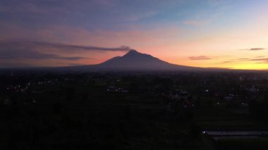 Gökyüzü hala karanlıkken ve güneş doğmadan önce Merapi Dağı 'nın güzelliğinin hava görüntüleri. Merapi Dağı 'nın güzel manzarası. Yükselen güneşten gelen altın renklerle karışık karanlık bir gökyüzü.