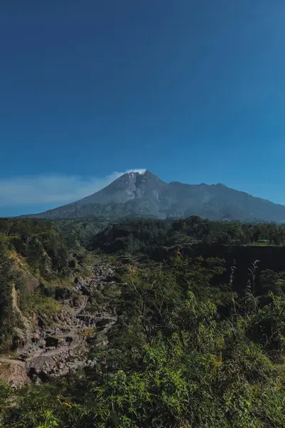 Merapi Dağı 'nın manzarası yazın sabahları çok güzeldir. Aktif volkan manzarası. Önünde orman ve vadi var.