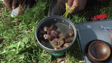 Güzel ve sakin bir yeşil pirinç tarlasında istiridye soslu biftek pişirirken ASMR ses çıkaran çalılık kavramı. Basit ekipman ve malzemelerle doğada yemek pişirme ve yeme süreci