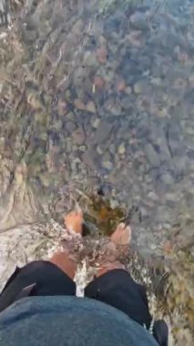 Nehirdeki bir maceracının POV 'u. Suyun berrak olduğu ve manzaranın çok güzel olduğu yer. Yeşil çimlerle çevrili sığ bir nehirde oynayan bir adamın bakış açısı