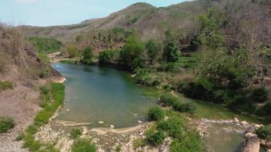 Yüksek uçurumlarla çevrili güzel manzaralı bir nehrin 4K hava manzarası. Nehrin kayalar ve ağaçlar arasında geniş bir alana yayılmış panoramik görüntüleri..