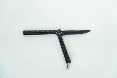 Kısmen açık mat siyah balisong ya da beyaz arka planda izole kelebek bıçağı. Keskin bir balisong bıçağının ya da kelebek bıçağının beyaz arka planda çeşitli pozisyonlarda yakın plan görüntüsü.