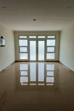 Yansıtıcı seramik zemini ve temiz beyaz duvarları olan kusursuz apartman kapıları. Mimari bina inşaatı simetrik ve minimalist bina kapıları şeklinde.