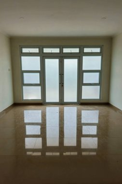 Yansıtıcı seramik zemini ve temiz beyaz duvarları olan kusursuz apartman kapıları. Mimari bina inşaatı simetrik ve minimalist bina kapıları şeklinde.