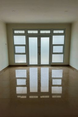 Yansıtıcı seramik zemini ve temiz beyaz duvarları olan kusursuz apartman kapıları. Mimari bina inşaatı simetrik ve minimalist bina kapıları şeklinde.