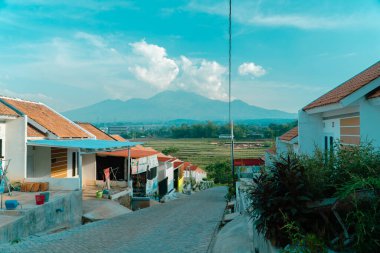 Yeşil pirinç tarlaları ve uzak mesafeden muhteşem görünen dağlarla çevrili güzel manzaralı bir yerleşim yeri. Dağlık manzaralı eğimli tepelerdeki kamu konutları