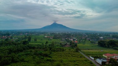 Kırsal kesimdeki sabah atmosferinin havadan çekilmiş fotoğrafı. Merapi Dağı 'nın çok görkemli bir manzarası var. Kırsal kesimde sabah atmosferi ve arka planda bir yanardağ.