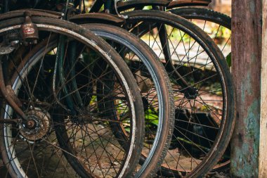 Pas dolu ve yıpranmış klasik bir bisiklete yaklaş. İhmal edilmiş ve tozla dolu eski bisiklet parçaları paslanmaya ve gözeneklenmeye başlamış gibi görünüyor.