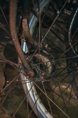 Pas dolu ve yıpranmış klasik bir bisiklete yaklaş. İhmal edilmiş ve tozla dolu eski bisiklet parçaları paslanmaya ve gözeneklenmeye başlamış gibi görünüyor.