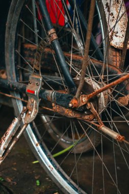Pas dolu ve yıpranmış klasik bir bisiklete yaklaş. İhmal edilmiş ve tozla dolu eski bisiklet parçaları paslanmaya ve gözeneklenmeye başlamış gibi görünüyor.