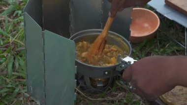 Roti Canai ile köri pişirirken çam ormanlarında tek başına kamp yapma fikri. Asyalı bir erkek maceracı, güzel doğada yemek pişirip hazırlanırken tek başına kamp yapar.