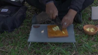 Roti Canai ile köri pişirirken çam ormanlarında tek başına kamp yapma fikri. Asyalı bir erkek maceracı, güzel doğada yemek pişirip hazırlanırken tek başına kamp yapar.