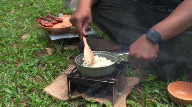 Çam ormanı bölgesinde kamp ve macera aktiviteleri çadır kurarak ve mangal kömürü sobası kullanarak ızgara karides ve limon yaprağı pilavı pişirerek. Bushcraft kavramı, doğada basit ekipman ve malzemelerle yemek pişirmek ve yemek yapmaktır.