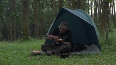 Çam ormanı bölgesinde kamp ve macera aktiviteleri çadır kurarak ve mangal kömürü sobası kullanarak ızgara karides ve limon yaprağı pilavı pişirerek. Bushcraft kavramı, doğada basit ekipman ve malzemelerle yemek pişirmek ve yemek yapmaktır.