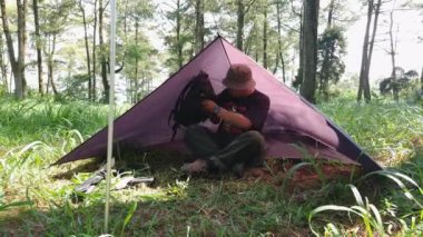 Çam ormanı bölgesinde kamp ve macera aktiviteleri bir tuzak kurarak ve yumurtalı pilav ve odun sobası kullanarak sıcak çay pişirerek. Bushcraft kavramı, doğada basit ekipman ve malzemelerle yemek pişirmek ve yemek yapmaktır..