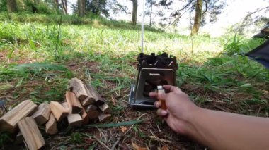Çam ormanı bölgesinde kamp ve macera aktiviteleri bir tuzak kurarak ve yumurtalı pilav ve odun sobası kullanarak sıcak çay pişirerek. Bushcraft kavramı, doğada basit ekipman ve malzemelerle yemek pişirmek ve yemek yapmaktır..
