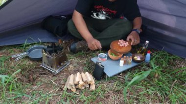 Çam ormanı bölgesinde kamp ve macera aktiviteleri bir tuzak kurarak ve yumurtalı pilav ve odun sobası kullanarak sıcak çay pişirerek. Bushcraft kavramı, doğada basit ekipman ve malzemelerle yemek pişirmek ve yemek yapmaktır..