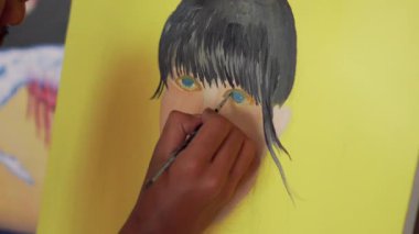 Fırça kullanarak tuvale parlak renkler uygulayan bir sanatçı. Bir ressamın bir kızın yüzünü pop tarzında boyama işleminden fırça darbelerine yakın çekim