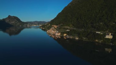 Şafak Lugano. Dağlık arazi. Como Gölü. Gandria köyü. Ağaçlardaki dağlar. İHA 'nın genel planı. Havadan ateş ediyorlar. Deniz kenarındaki şehir. Turist köyü. Doğa. İsviçre