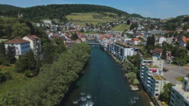Nehir kıyısında bir şehir. Avrupa şehri. İsviçre 'de küçük bir kasaba. Terracotta evlerin çatısı. Orman. Yaz. Konut alanı. Nehir. Çok katlı evler. Yeşil tepeler. Dağlık arazi. İsviçre