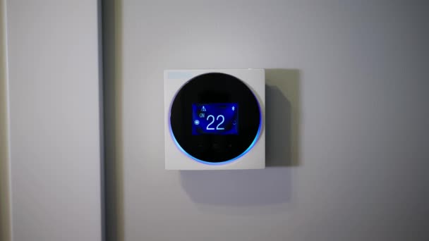 部屋の温度を設定する サーモスタットを介して家の温度を設定します サーモスタットを手動で設定する エアコン デジタルサーモスタット ホテルに リモートコントロールサーモスタット ある男 — ストック動画