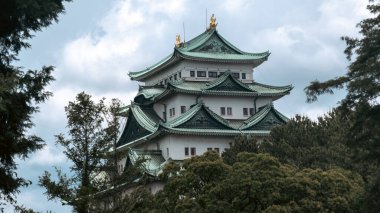 A cinematic-style picture of majestic Nagoya Castle, crowned with golden shachihoko, reflects Japan's rich history and the beauty of its Edo-era architecture, surrounded by serene gardens. clipart