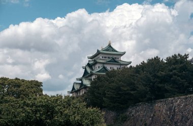 A cinematic-style picture of majestic Nagoya Castle, crowned with golden shachihoko, reflects Japan's rich history and the beauty of its Edo-era architecture, surrounded by serene gardens. clipart