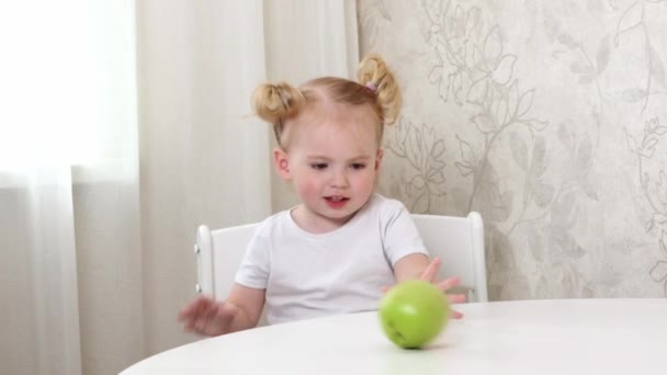 Маленька Дівчинка Білій Футболці Сидить Столом Грає Зеленим Яблуком — стокове відео