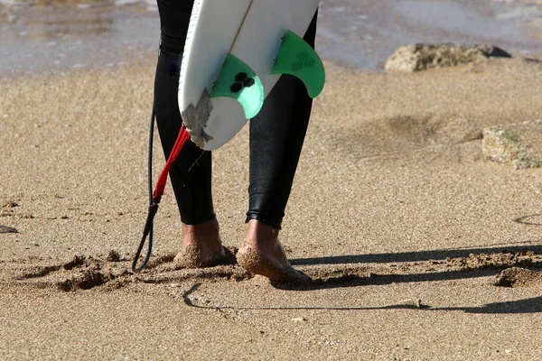 男は砂の上を裸足で海を歩いている — ストック写真