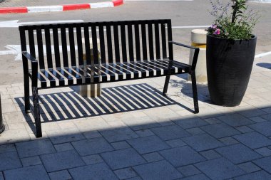 Deniz kıyısındaki şehir parkında dinlenmek için bankta..