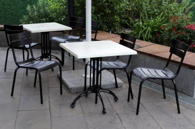 Chair and table in a cafe in a city park near the sea.
