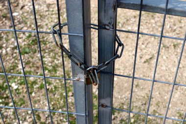 Kapıda eski bir asma kilit asılı.