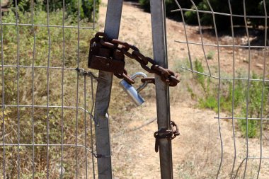 Kapıda eski bir asma kilit asılı.