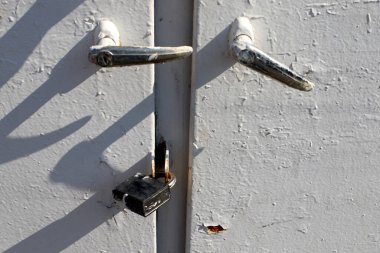 Kapıda eski bir asma kilit asılı.