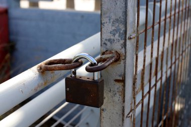 Kapıda eski bir asma kilit asılı.