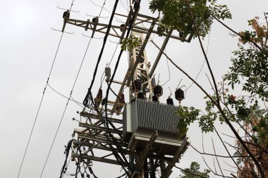 Yalıtkan kabloları olan elektrik direği..