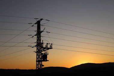 Yalıtkan kabloları olan elektrik direği..