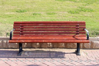 Akdeniz kıyısındaki bir şehir parkında dinlenmek için bankta..