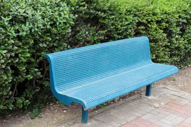 Akdeniz kıyısındaki bir şehir parkında dinlenmek için bankta..