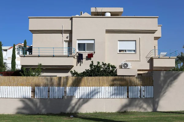 Şehir parkında çit boyunca yeşil bitkiler ve çiçekler yetişir..