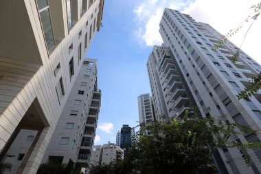 Tel Aviv 'de. İsrail. 01 numara. 01 numara. 2024. Büyük bir şehrin sokaklarında uzun evler ve ağaçlar.