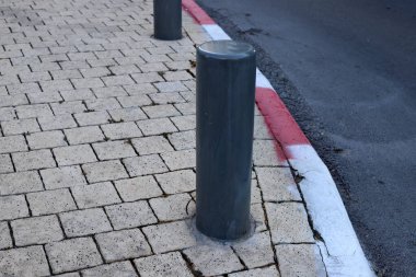 Yayaların güvenli geçişi için yol boyunca sütunlar var..