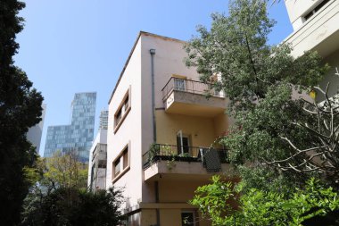 Tel Aviv İsrail 03 / 28 / 2024. Tel Aviv 'deki binalar ve yapılar yüksek ağaçların yaprakları arasında..