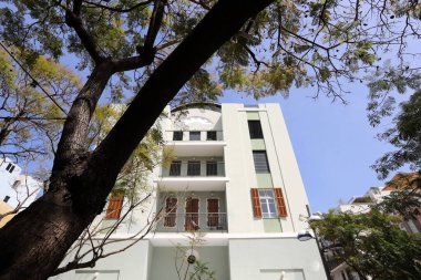 Tel Aviv İsrail 03 / 28 / 2024. Tel Aviv 'deki binalar ve yapılar yüksek ağaçların yaprakları arasında..