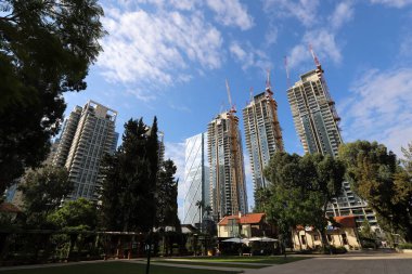 Tel Aviv İsrail 03 / 28 / 2024. Tel Aviv 'deki binalar ve yapılar yüksek ağaçların yaprakları arasında..