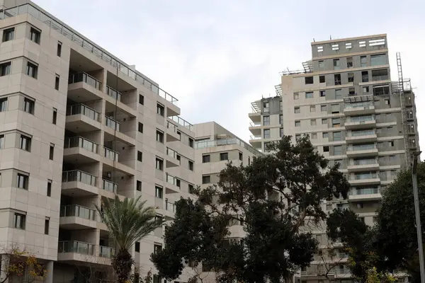 Tel Aviv İsrail 03 / 28 / 2024. Tel Aviv 'deki binalar ve yapılar yüksek ağaçların yaprakları arasında..