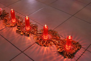 Masanın üzerinde yanan bir mum duruyor..