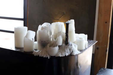 Masanın üzerinde yanan bir mum duruyor..